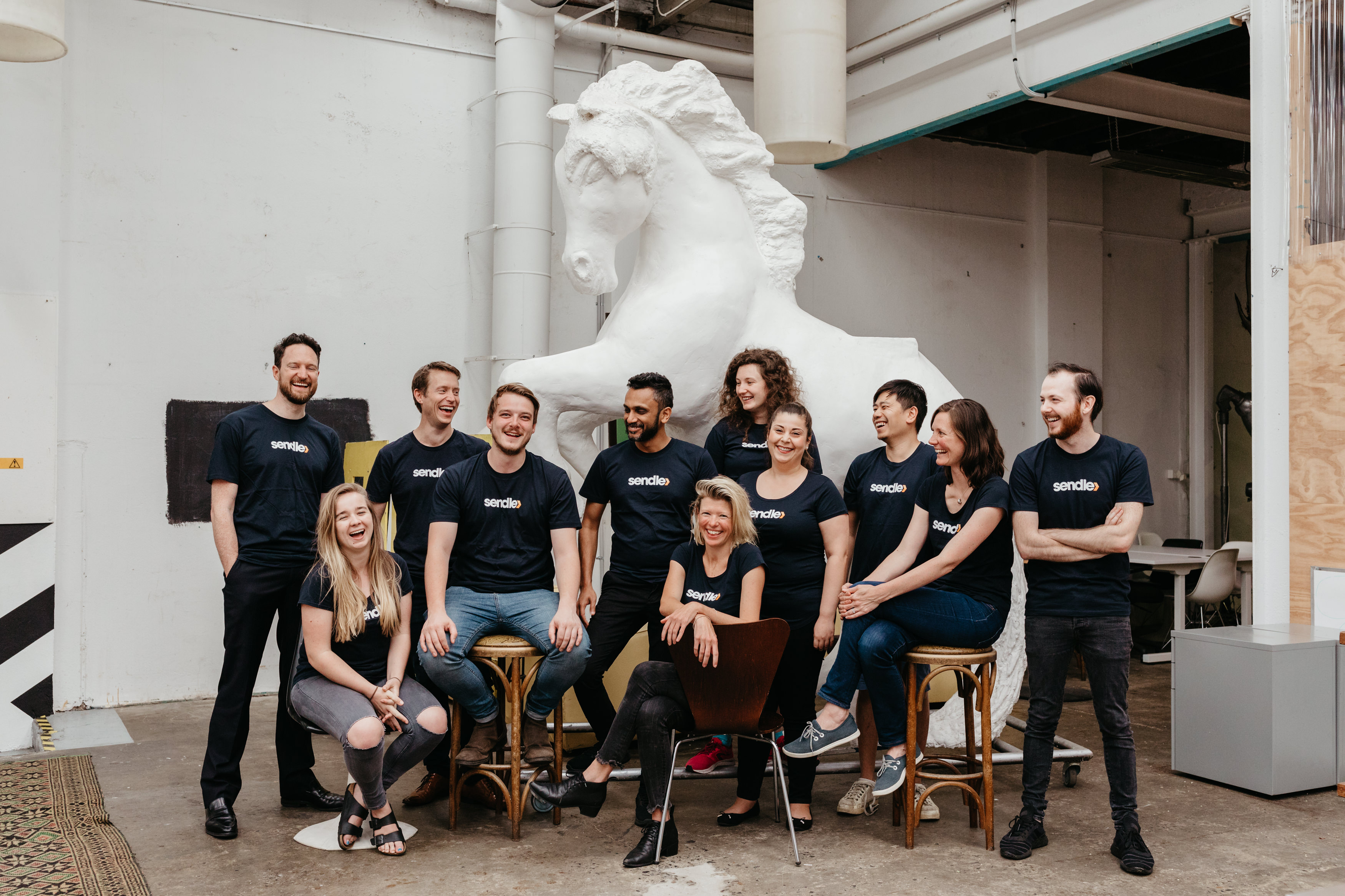 ​  The Sendle team pose in front of a large plaster equestrian statue