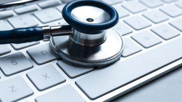 stethoscope resting atop mac keyboard